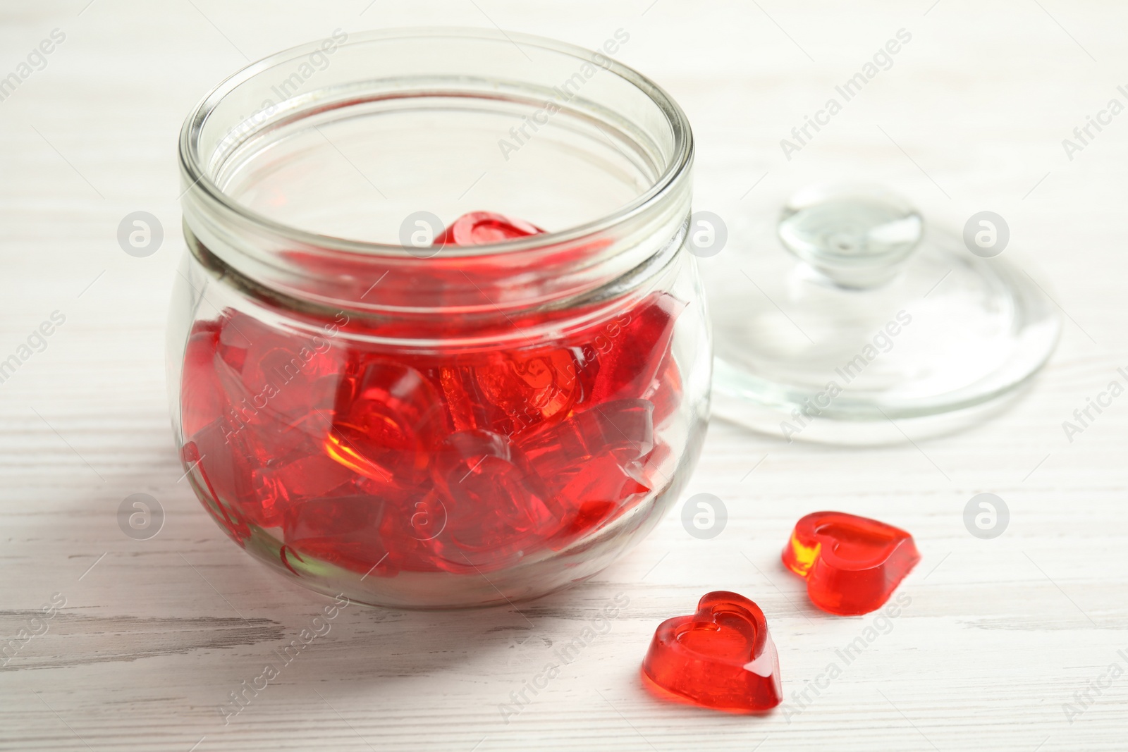 Photo of Tasty heart shaped jelly candies on white table