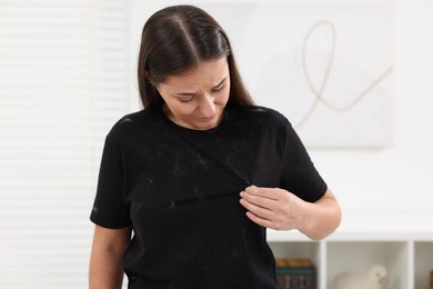 Woman with pet hair on her black clothers at home