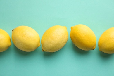 Photo of Fresh lemons on turquoise background, flat lay