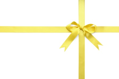 Photo of Yellow satin ribbon with bow on white background, top view