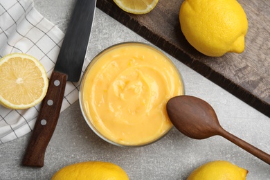 Delicious lemon curd in bowl on grey table, flat lay