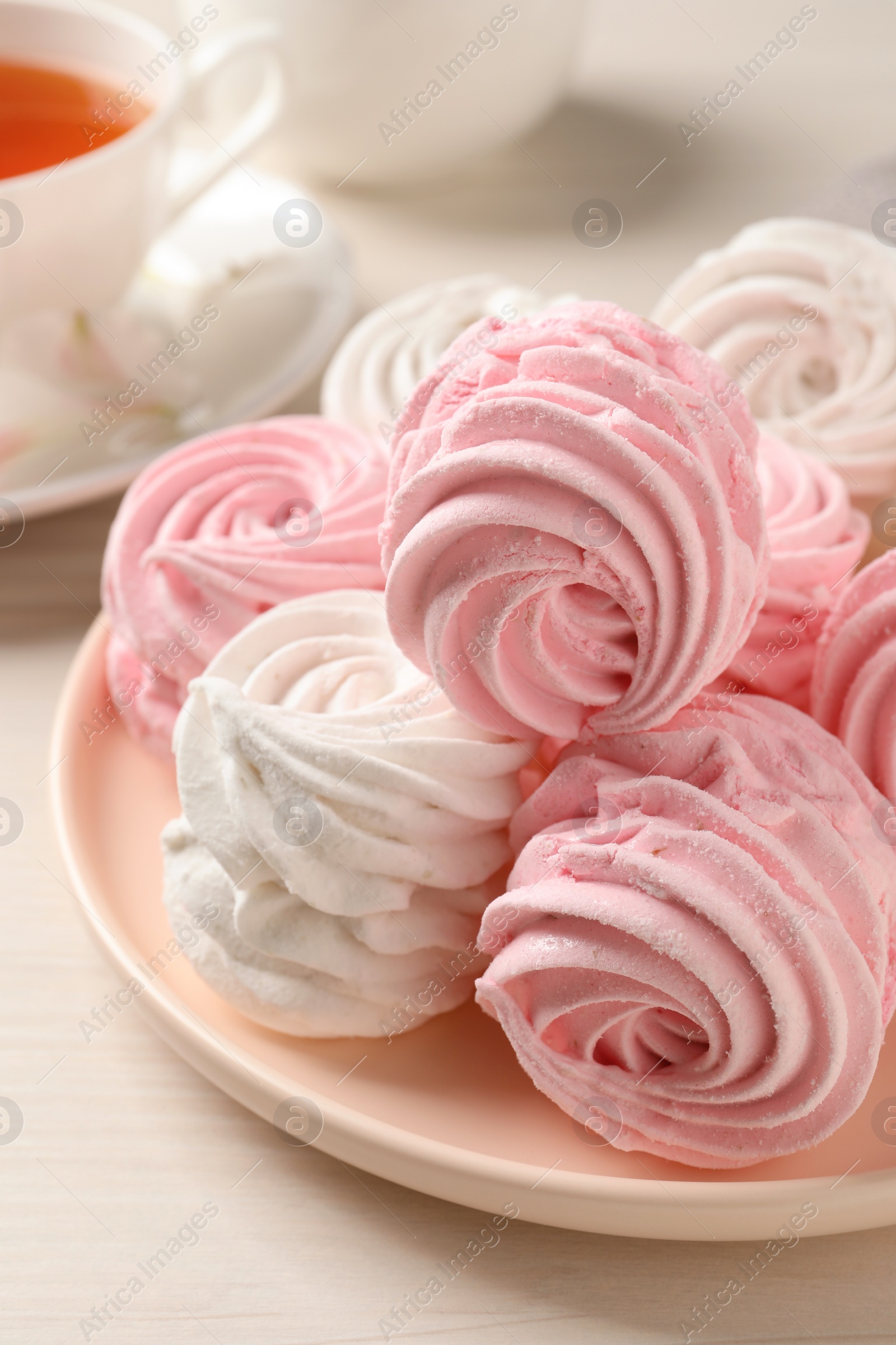 Photo of Plate with delicious pink zephyrs on white table, closeup