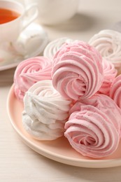 Photo of Plate with delicious pink zephyrs on white table, closeup
