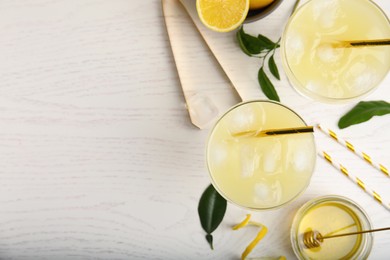 Photo of Delicious bee's knees cocktails and ingredients on white wooden table, flat lay. Space for text