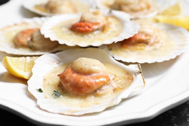 Photo of Fried scallops in shells and lemon on table, closeup