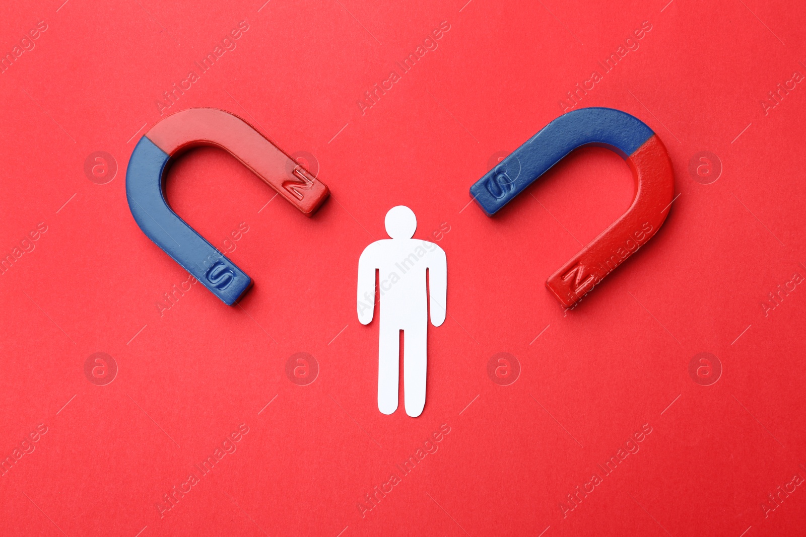 Photo of Magnets attracting paper man on color background, top view. Business rivalry concept