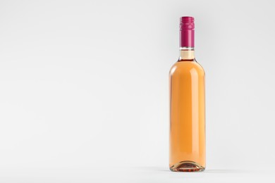 Photo of Bottle of expensive rose wine on light background. Space for text