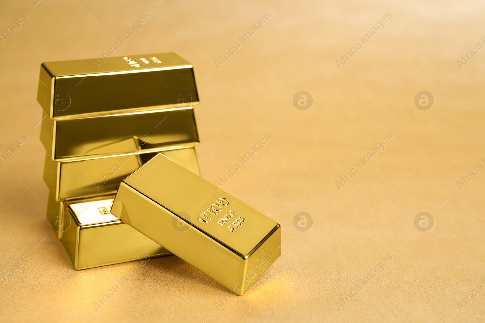 Photo of Many shiny gold bars on color background. Space for text