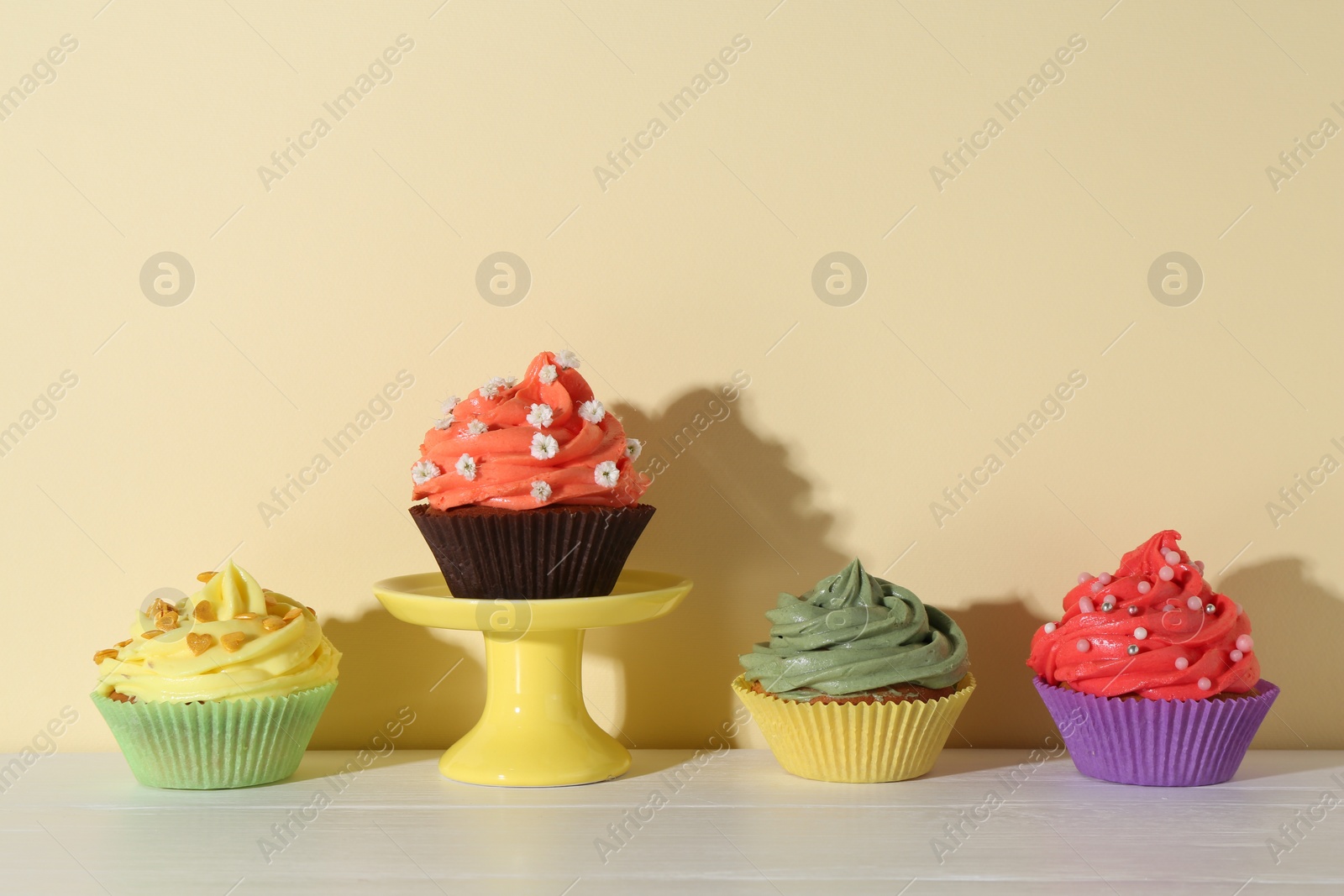 Photo of Delicious cupcake with bright cream on white wooden table. Space for text