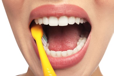 Woman brushing teeth on white background, closeup. Dental care