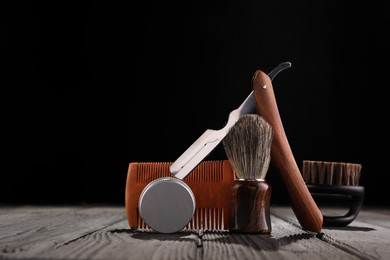 Moustache and beard styling tools on wooden table. Space for text