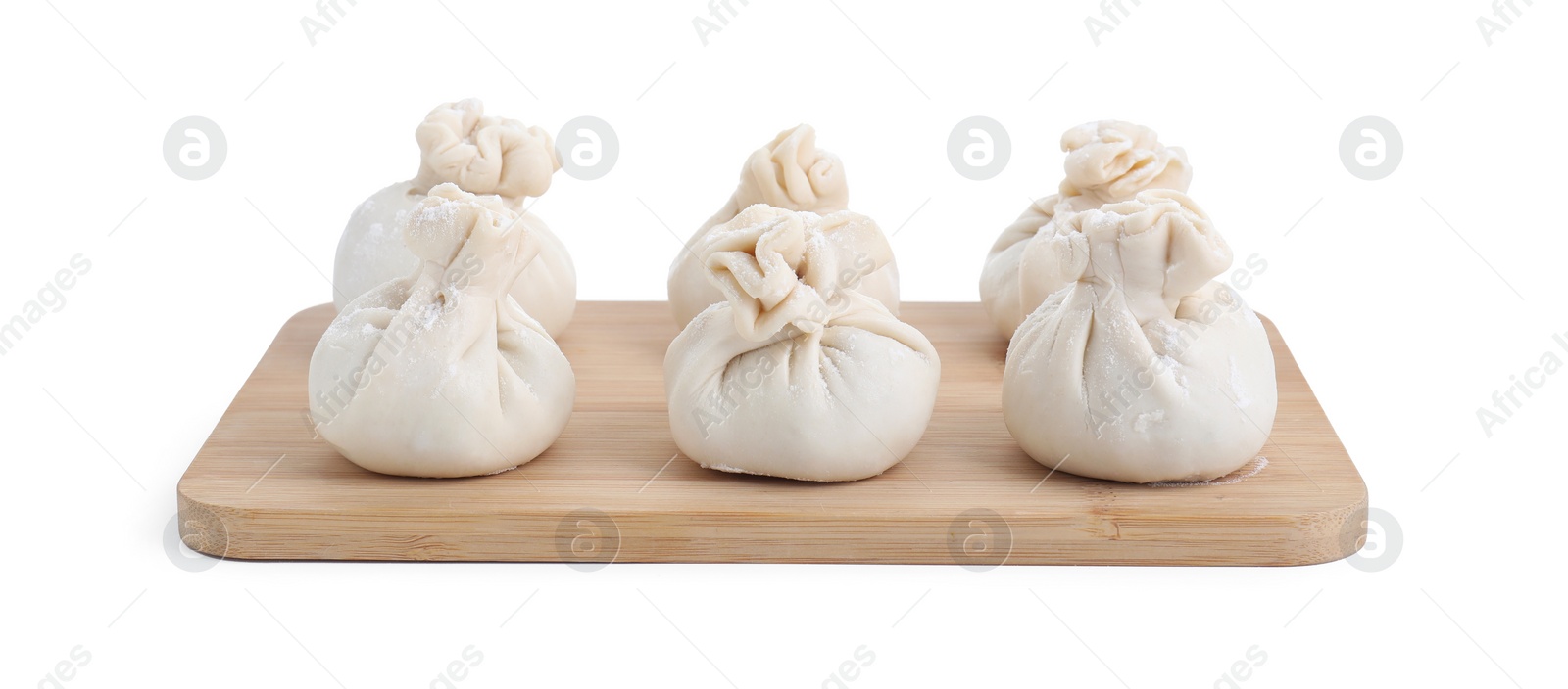 Photo of Wooden board with uncooked khinkali (dumplings) isolated on white. Georgian cuisine