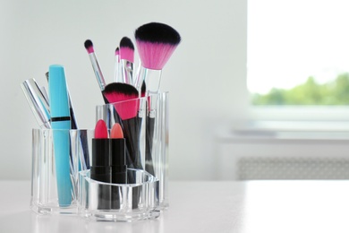 Organizer with makeup cosmetic products on table indoors. Space for text