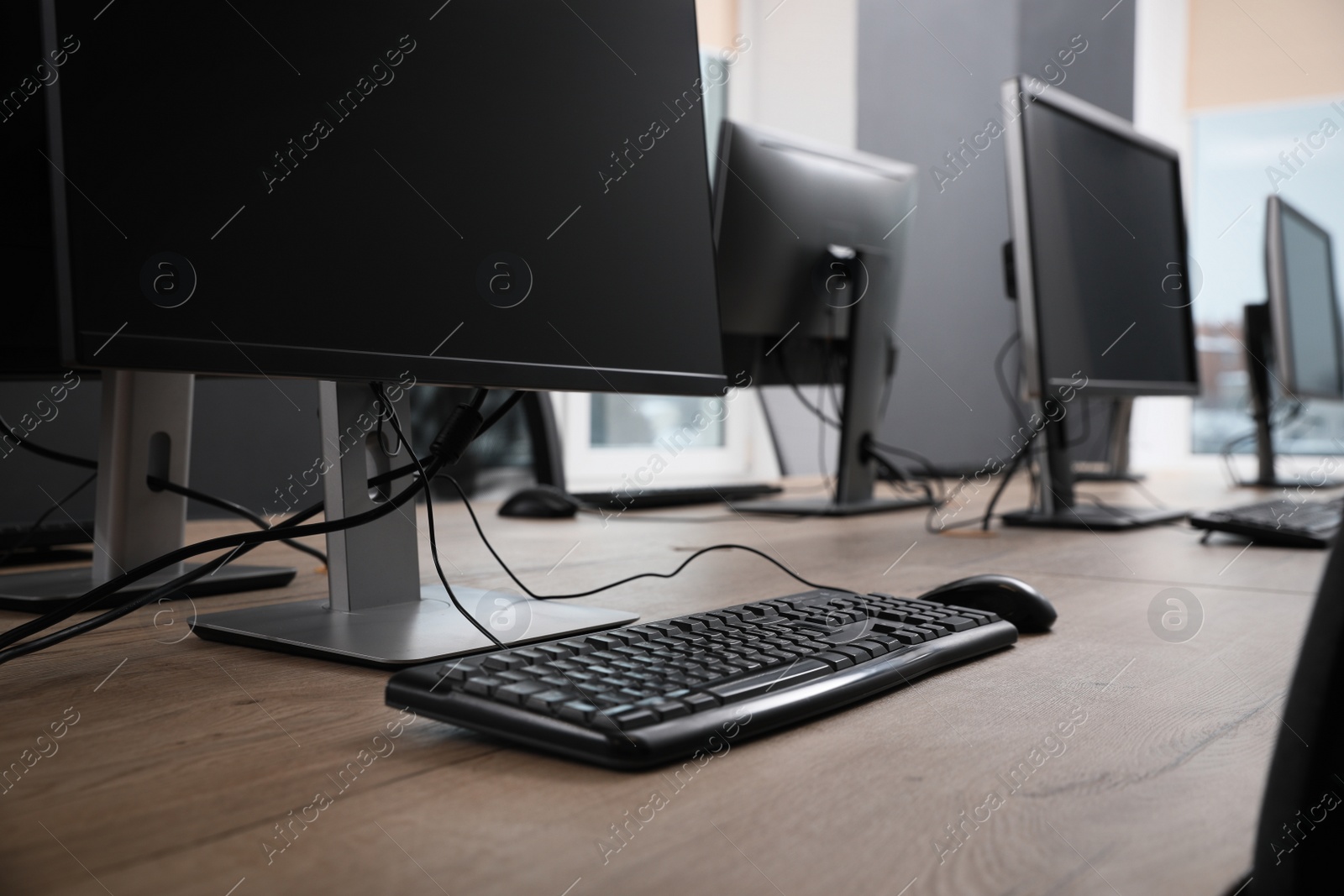 Photo of Many modern computers in open space office, closeup view