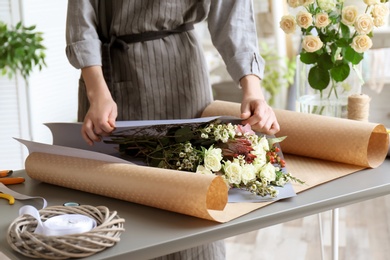 Photo of Female florist creating bouquet at workplace