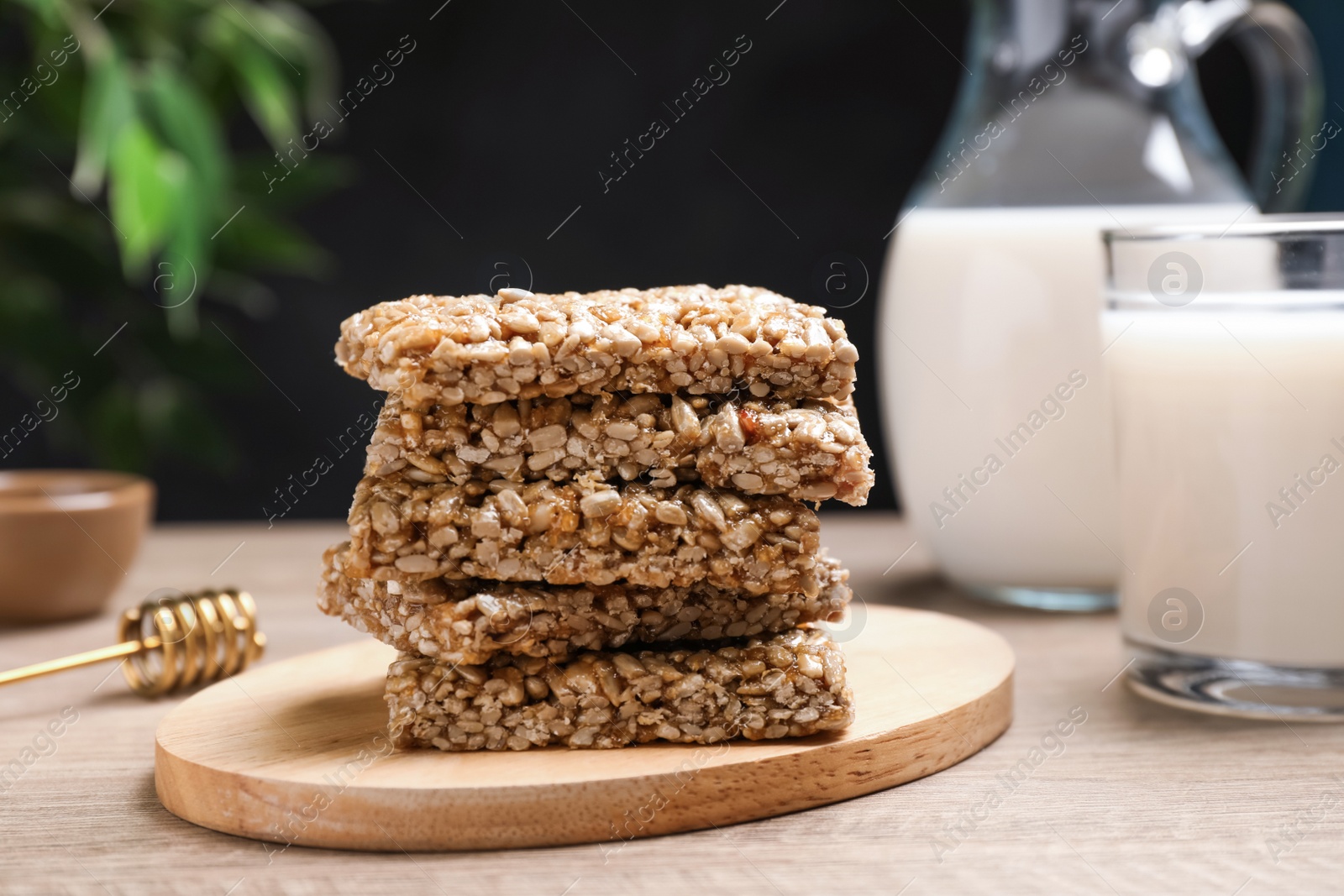 Photo of Delicious sweet kozinaki bars and milk on wooden table