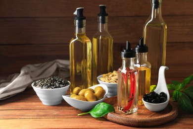 Photo of Different cooking oils and ingredients on wooden table