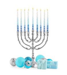 Photo of Hanukkah celebration. Menorah with colorful candles, festive baubles and gift boxes isolated on white