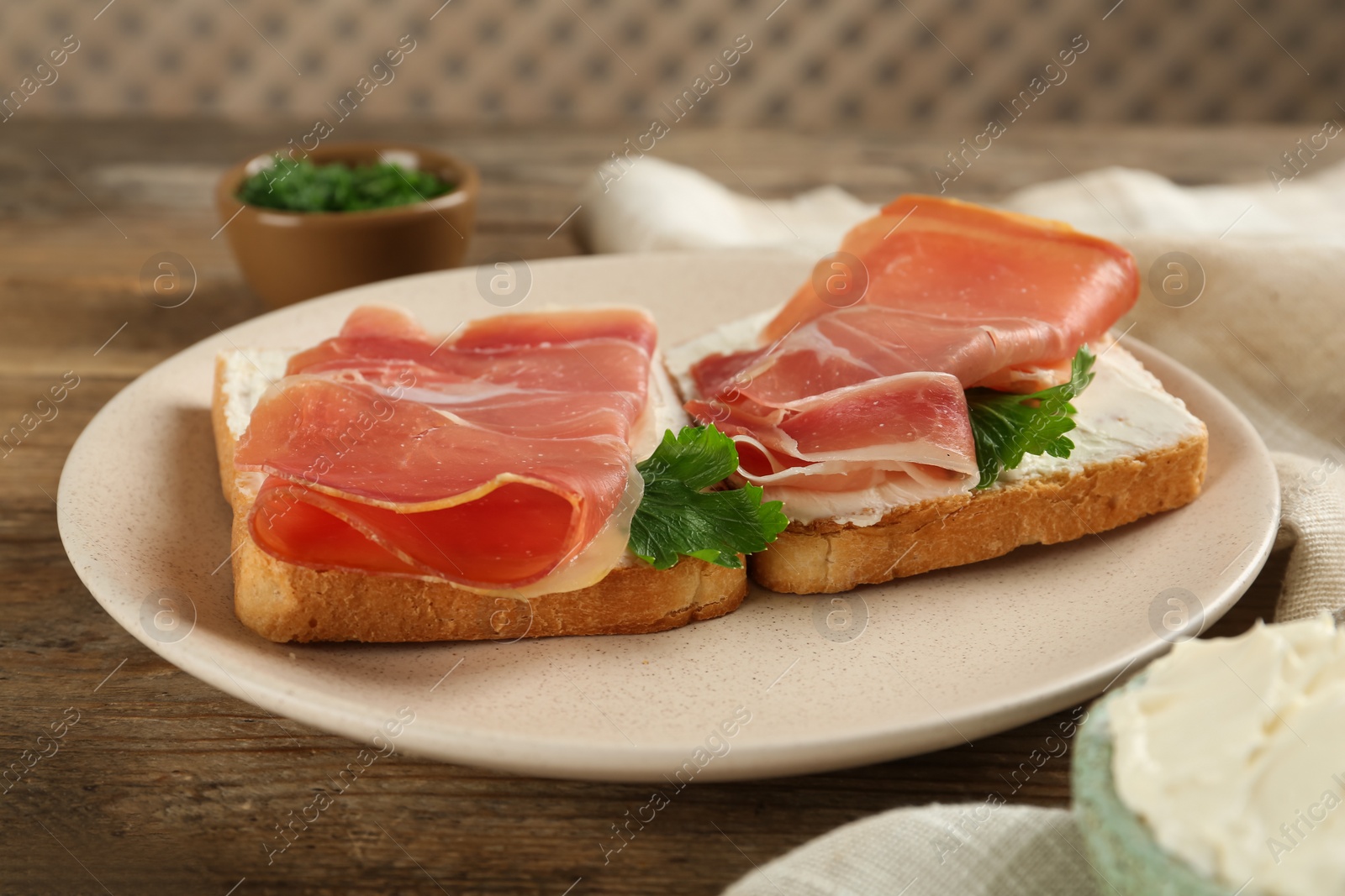 Photo of Delicious sandwiches with cream cheese and jamon on wooden table
