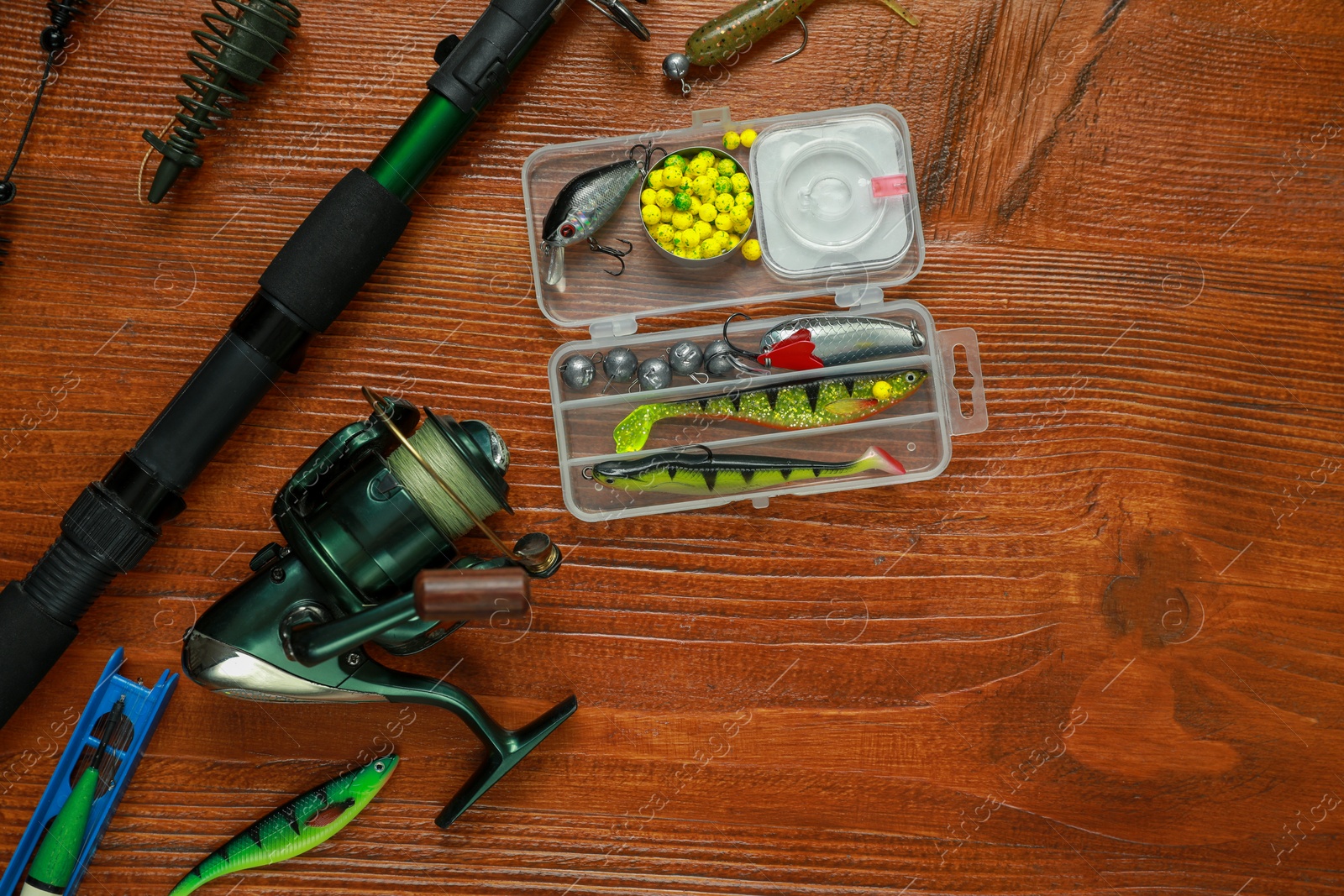 Photo of Fishing tackle on wooden table, flat lay. Space for text