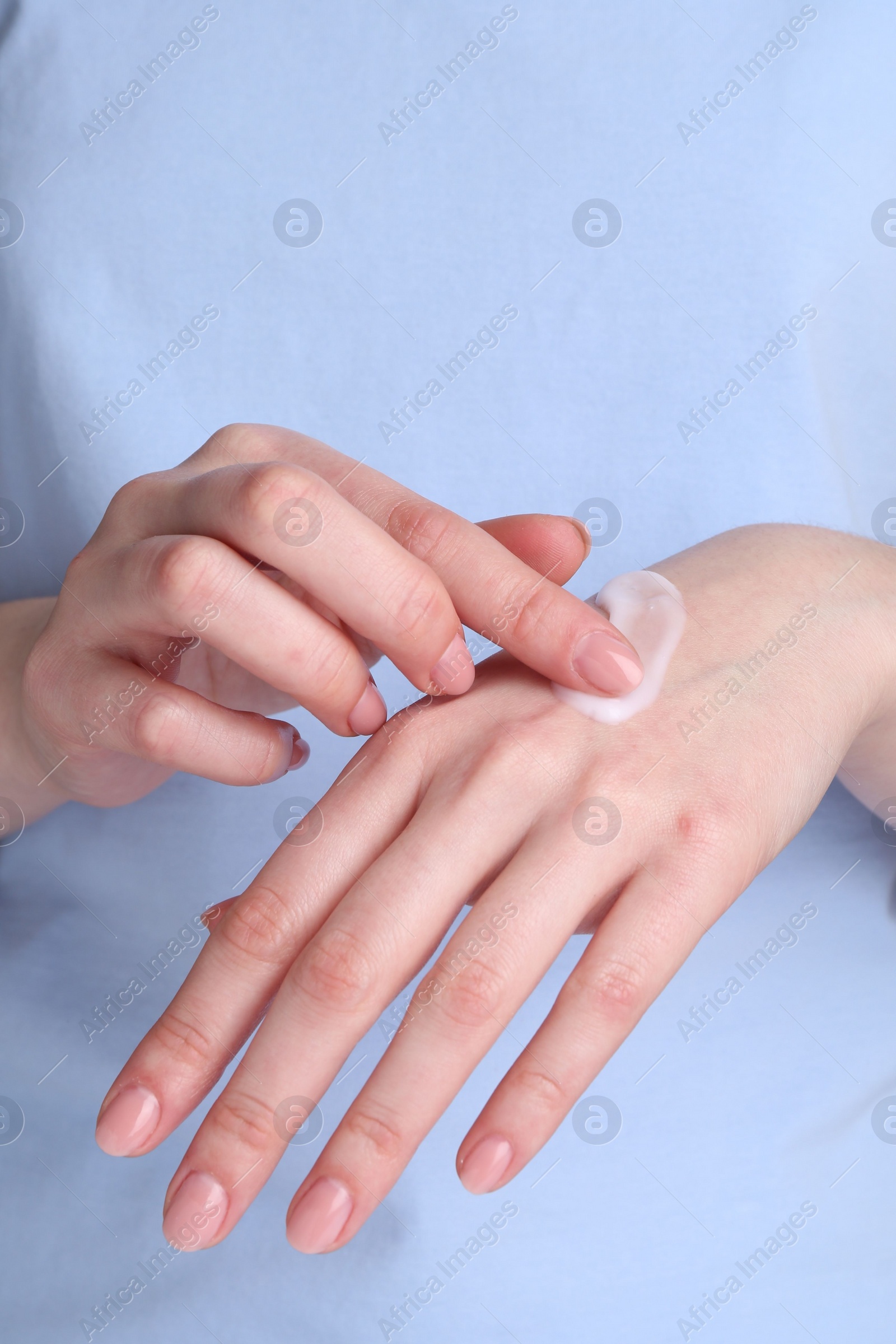 Photo of Woman applying cream on her hands, closeup