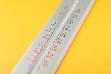 Photo of Modern weather thermometer on yellow background, closeup