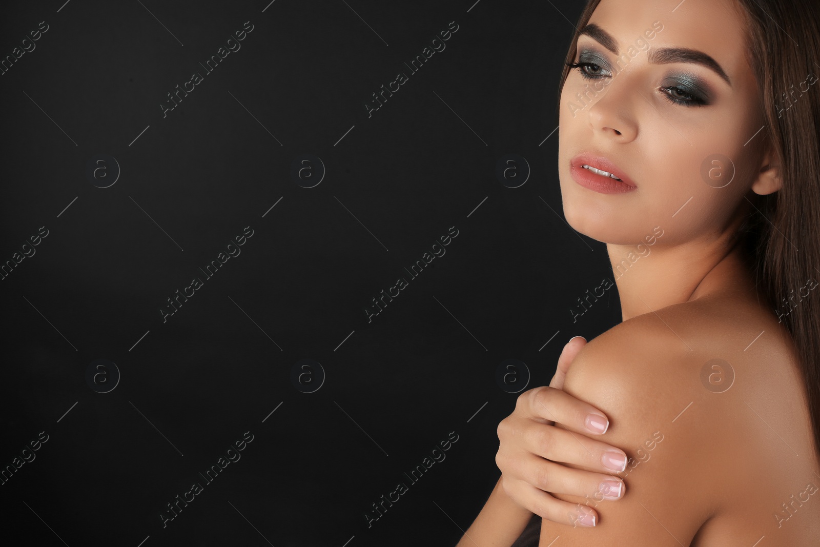 Photo of Portrait of beautiful woman with stylish makeup on dark background. Space for text