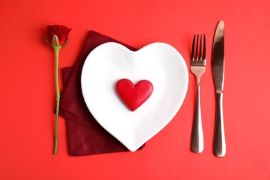 Photo of Elegant table setting for romantic dinner on red background, flat lay. Valentine's day celebration