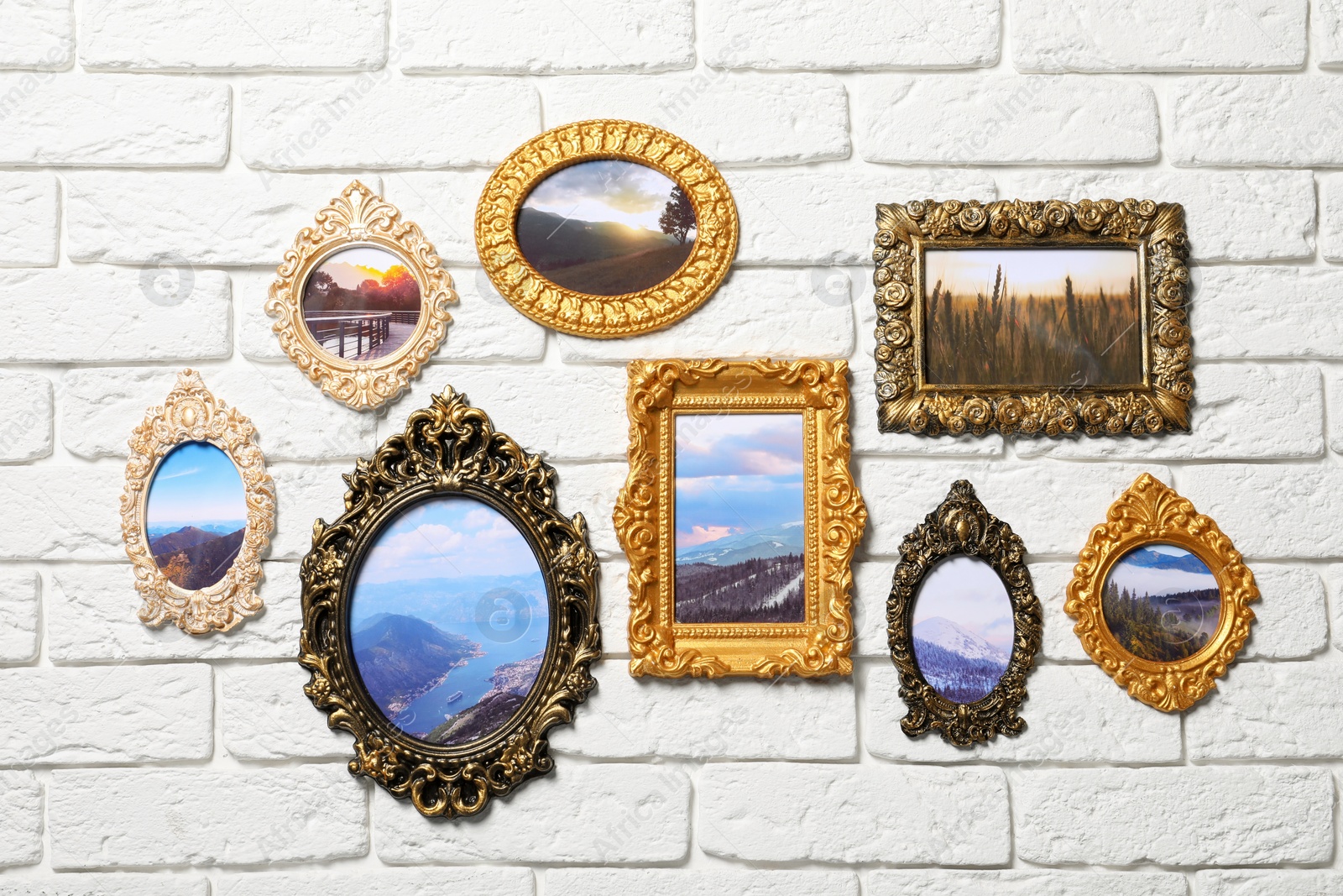 Photo of Vintage frames with photos of beautiful landscapes hanging on white brick wall