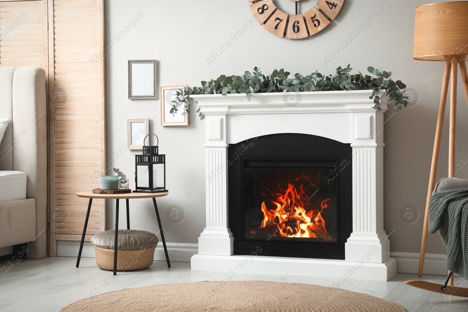 Photo of Stylish room decorated with beautiful eucalyptus garland on fireplace