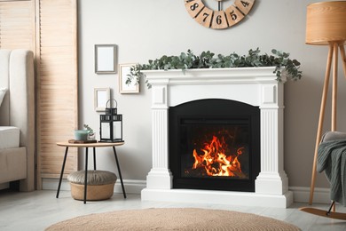 Stylish room decorated with beautiful eucalyptus garland on fireplace