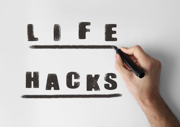 Image of Life hacks. Man underlining word with marker on whiteboard, closeup