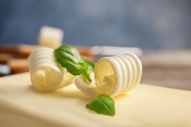 Photo of Piece of tasty butter with curls, closeup