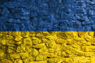 Image of National flag of Ukraine painted on old stone wall