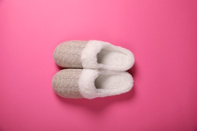 Photo of Pair of beautiful soft slippers on pink background, top view