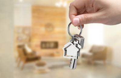 Image of Woman holding house keys in room, closeup