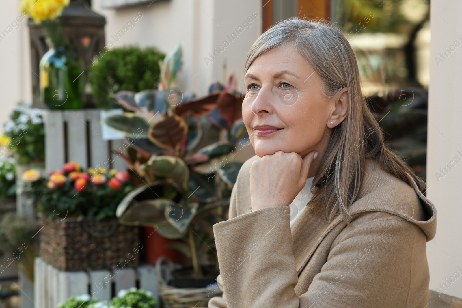 Photo of Beautiful senior woman sitting outdoors, space for text
