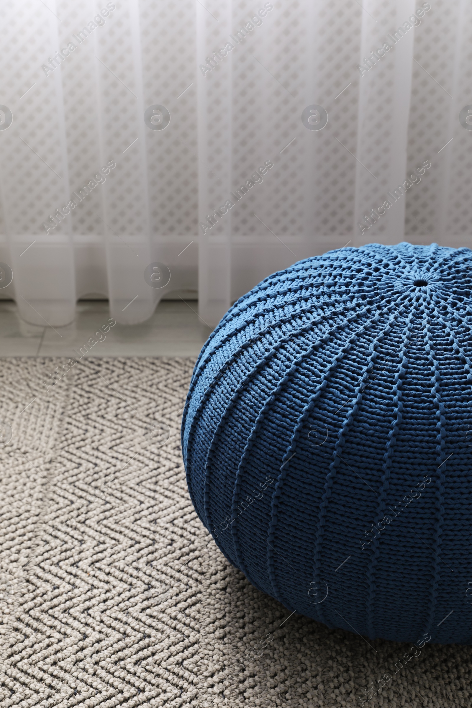 Photo of Stylish blue pouf on floor in room