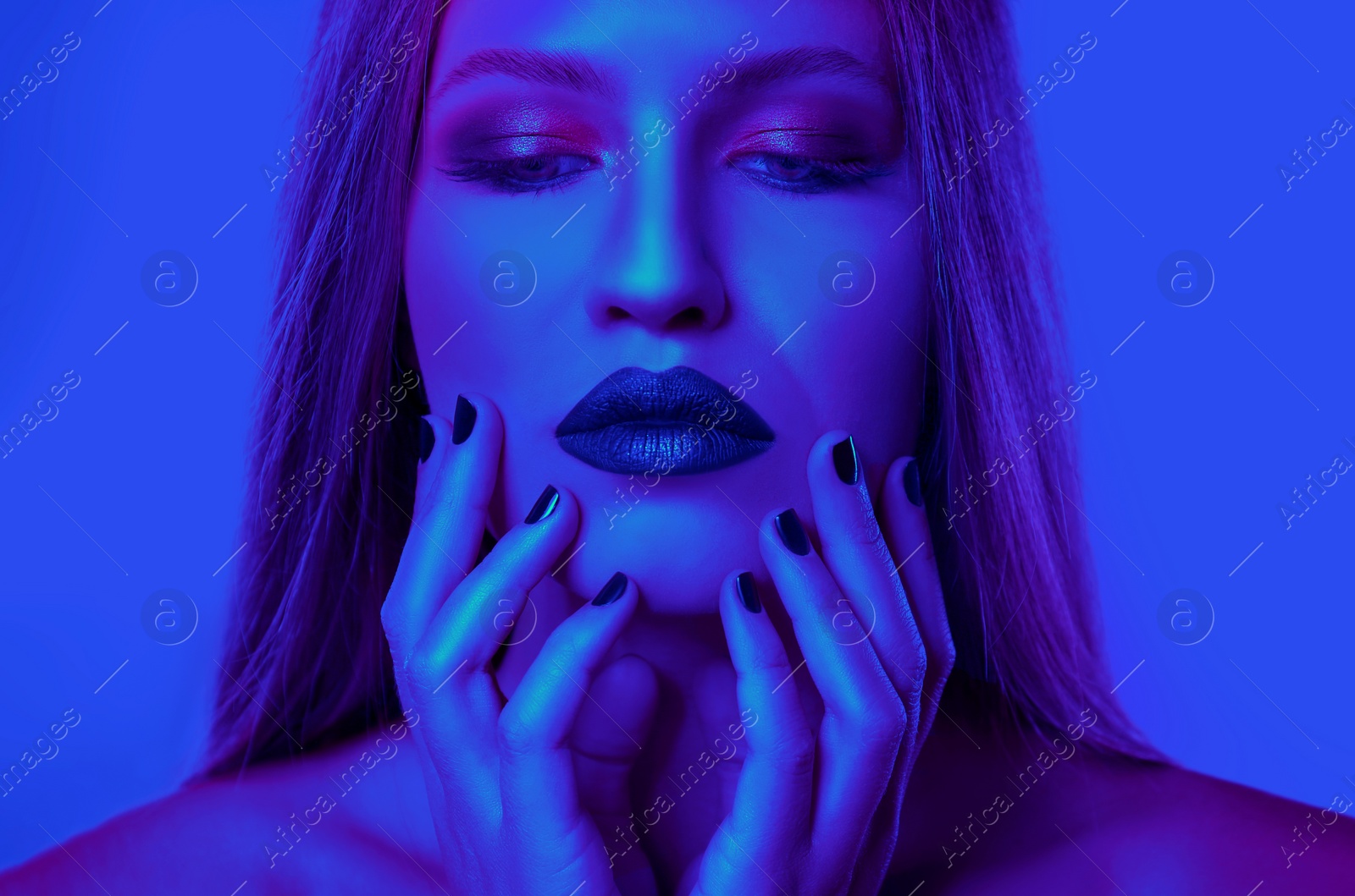 Image of Young woman with beautiful makeup posing in neon lights