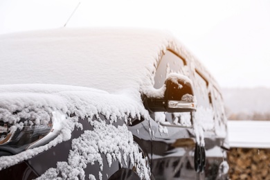 Car covered with snow after storm outdoors on beautiful winter day, closeup