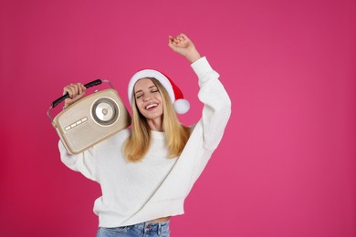 Photo of Happy woman with vintage radio on pink background, space for text. Christmas music