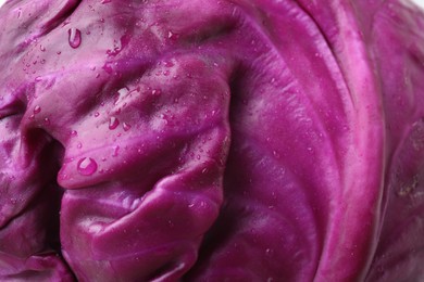 Photo of Fresh red cabbage with water drops as background, closeup
