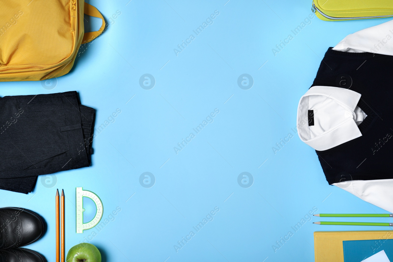 Photo of Flat lay composition with school uniform on blue background. Space for text