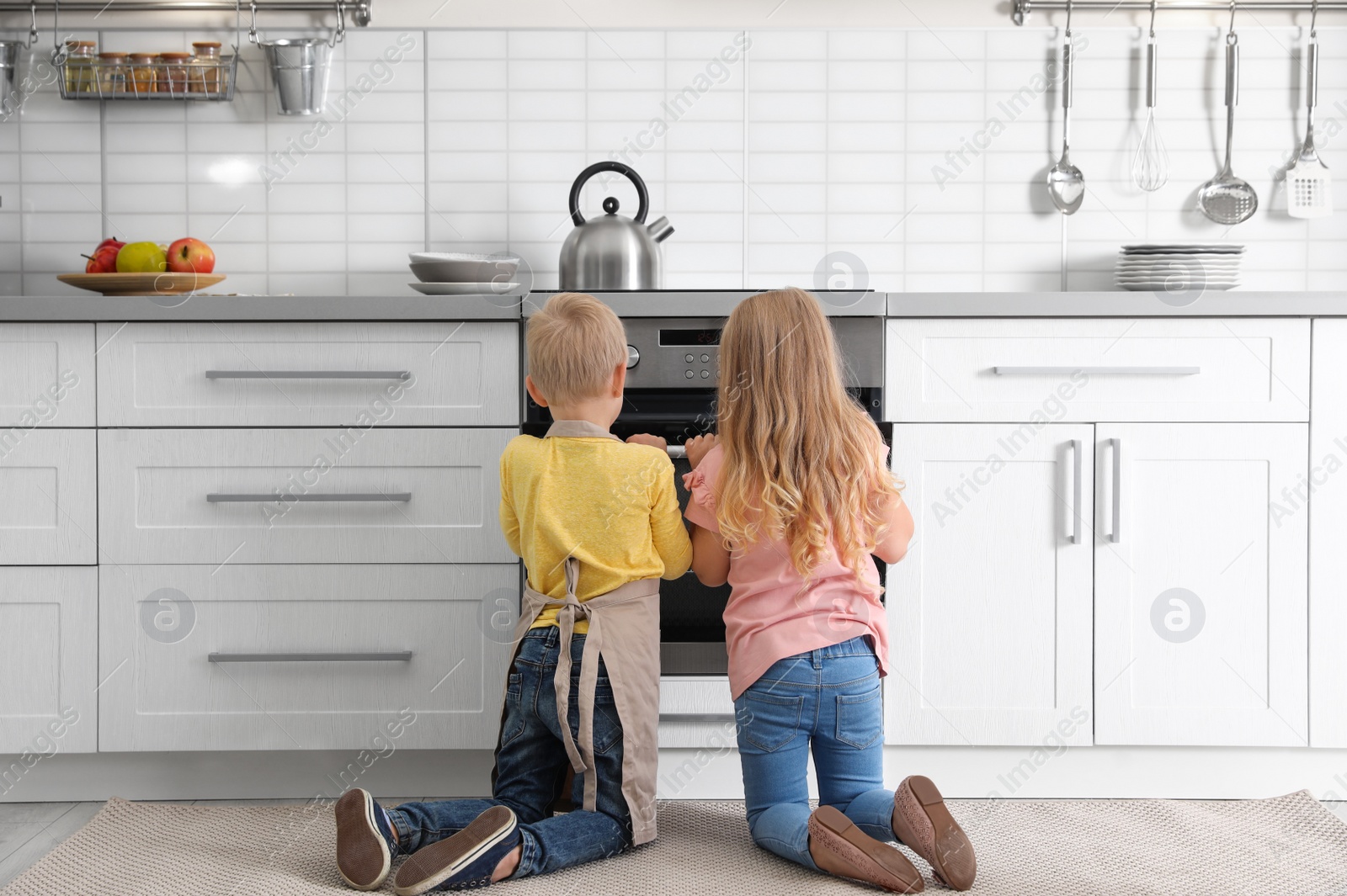 Photo of Little kids baking something in oven at home