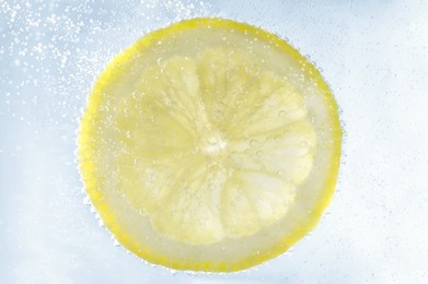 Juicy lemon slice in soda water, closeup