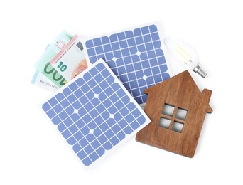 Photo of Composition with solar panels and wooden house model on white background, top view