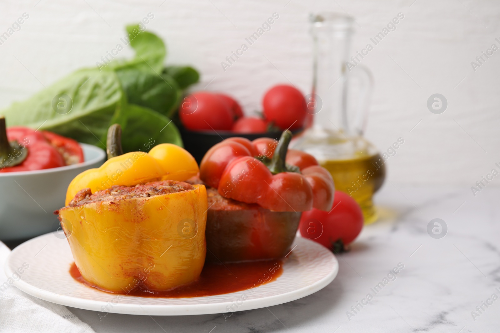 Photo of Delicious stuffed bell peppers served on white marble table. Space for text