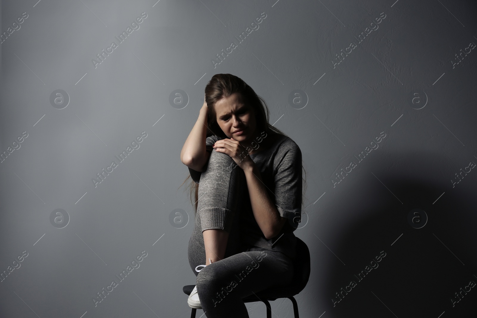 Photo of Depressed young woman on gray background