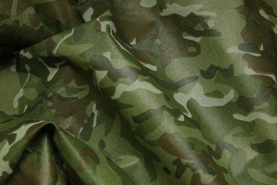 Texture of crumpled camouflage fabric as background, top view