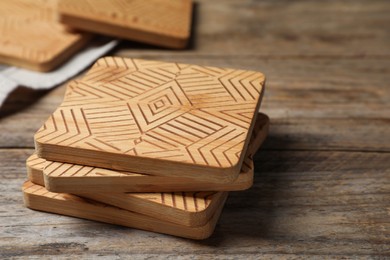 Photo of Stylish cup coasters on wooden table, closeup. Space for text